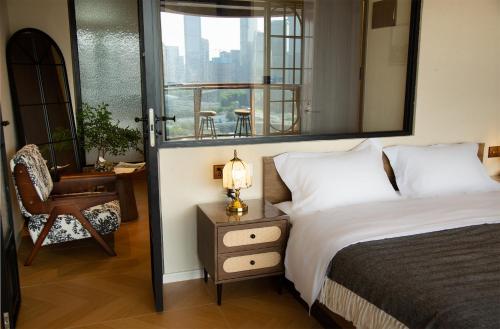 a bedroom with a bed and a chair and a mirror at Chongqing Shangshanzhu Riverside View Homestay in Chongqing