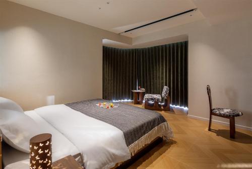 a bedroom with a large white bed and a window at Chongqing Shangshanzhu Riverside View Homestay in Chongqing