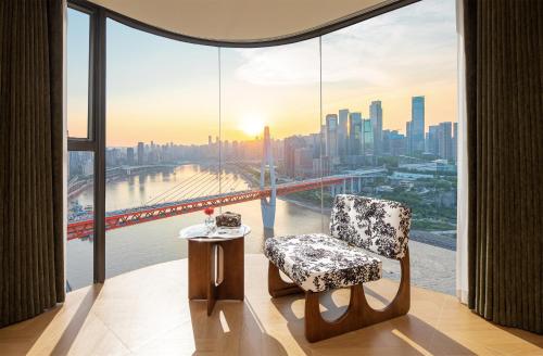 a room with a chair and a view of a city at Chongqing Shangshanzhu Riverside View Homestay in Chongqing