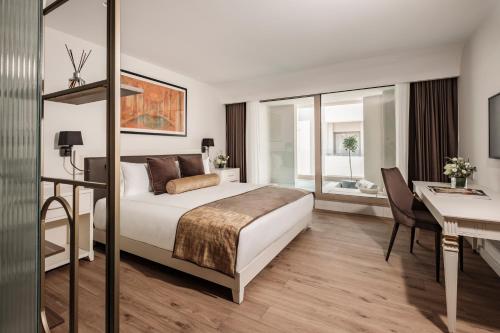 a hotel room with a bed and a desk and a desk at 1926 Les Bains Private Spa Suites in Sliema