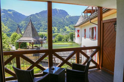 a balcony with chairs and a view of a golf course at Schlosshotel Kitzbühel in Kitzbühel