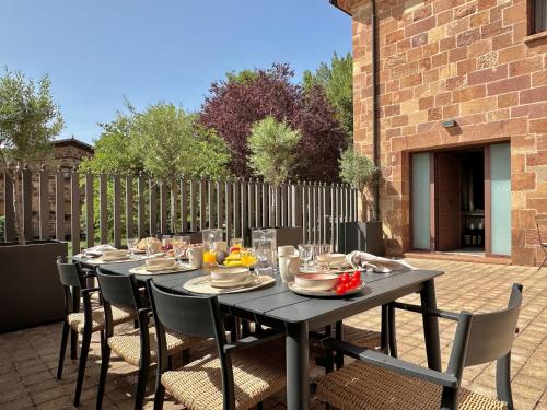 a black table with chairs and food on a patio at Casa Rural Pacelia in Salgüero de Juarros