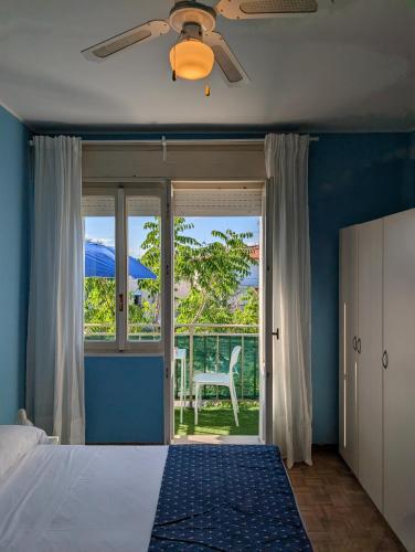 a bedroom with a bed and a window with a chair at Alloggi San Marco in Caorle