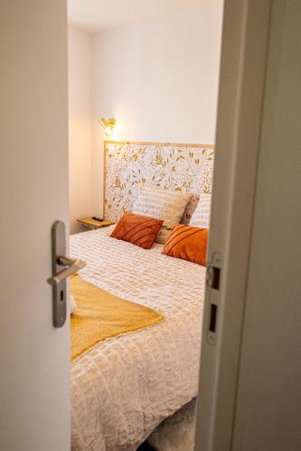 a bedroom with a large bed with orange pillows at Gite Au Charme des Iris in Plérin