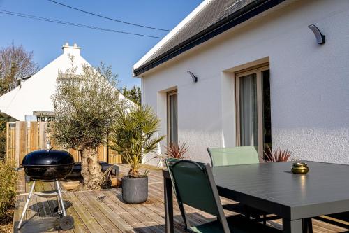 a patio with a black table and chairs and a grill at Gite Au Charme des Iris in Plérin