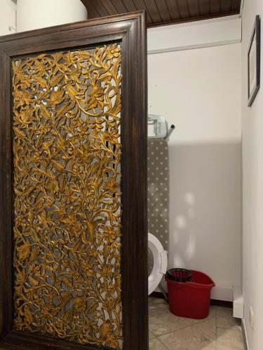 a bathroom with a wooden door with a screen with a toilet at Discovery Apartment Carnaxide in Carnaxide