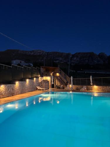a large swimming pool at night with lights at Kairos B&B in San Giuseppe Jato