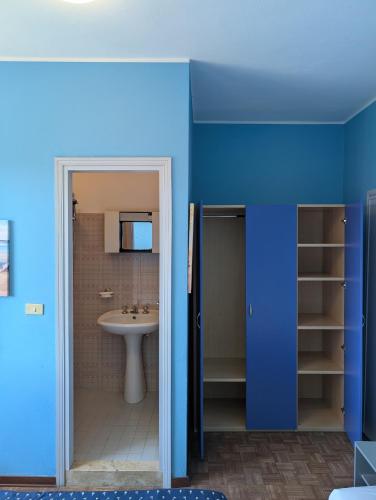 a bathroom with a sink and a blue wall at Alloggi San Marco in Caorle