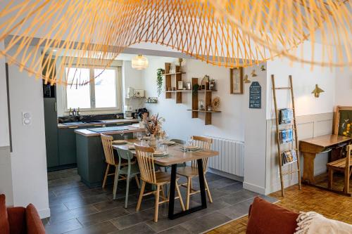 a kitchen and dining room with a table and chairs at Gite Au Charme des Iris in Plérin