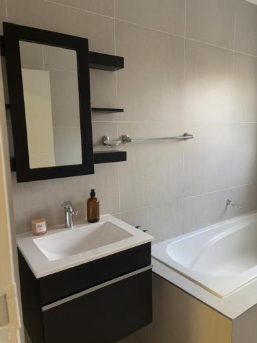 a bathroom with a sink and a mirror and a tub at The Hideaway at The Palms in Kimberley