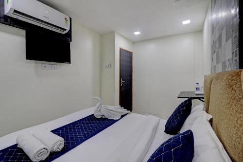 ein Hotelzimmer mit einem Bett und einem Flachbildfernseher in der Unterkunft Parle Inn Hotel in Mumbai