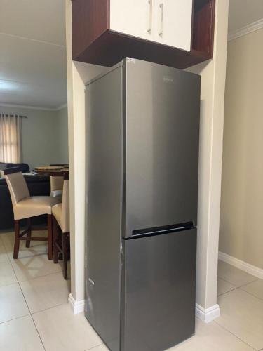 a stainless steel refrigerator in a kitchen with a table at The Hideaway at The Palms in Kimberley