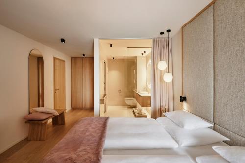 a bedroom with a large white bed and a bathroom at Haven Mountain Retreat in Sankt Johann im Pongau