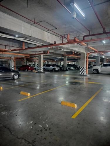 a parking lot with cars parked in a parking garage at Cozy Studio Unit in Quezon City with Private Pool and City Views in Manila