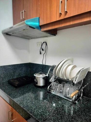 a kitchen counter top with a pot and a sink at Modern Condo in Quezon City with Private Pool and City Views in Manila