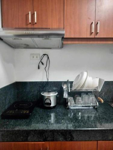 a kitchen counter with a sink with dishes in it at Modern Condo in Quezon City with Private Pool and City Views in Manila