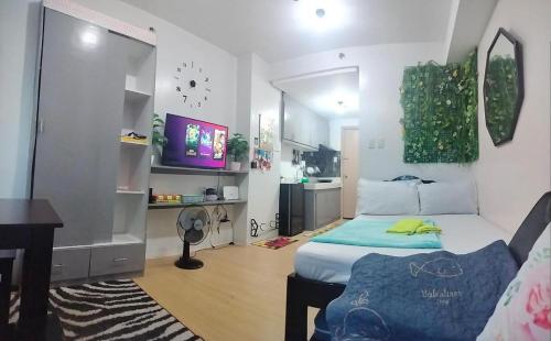 a bedroom with a bed and a table and a desk at Cozy City View Condo in Quezon City - Your Home Away from Home in Manila