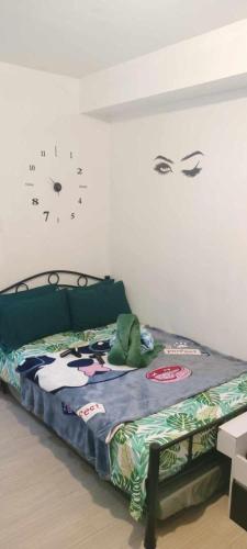 a bedroom with a bed with a clock on the wall at Luxurious 9th Floor Studio in Quezon City with Private Pool in Manila
