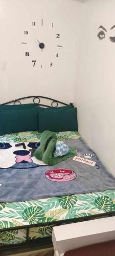 a bedroom with a bed with a clock on the wall at Luxurious 9th Floor Studio in Quezon City with Private Pool in Manila