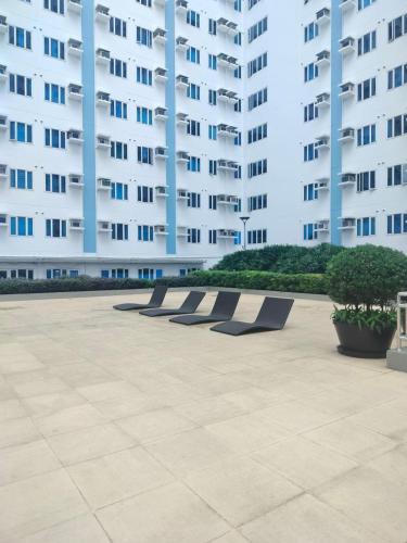 a row of benches in front of a large building at Luxurious Condo in Quezon City with Private Pool and City Views in Manila