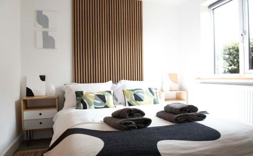 a bedroom with a bed with towels on it at Dorset Stylish Apartment in Poole