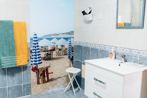 a bathroom with a sink and a view of the beach at Casa da Avó Bela in Buarcos