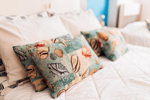 un grupo de almohadas sentado encima de una cama en Casa da Avó Bela, en Buarcos