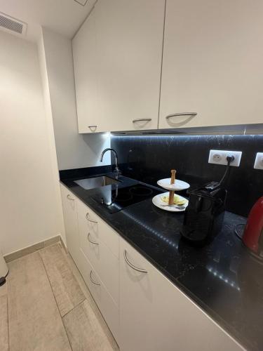 une cuisine avec un comptoir noir avec une assiette de nourriture dans l'établissement La Maison de la Tour, à La Tour