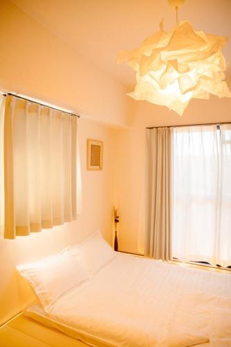 a bedroom with a bed and a chandelier at 和605 名駅徒歩圏 地下鉄徒歩3分 最大4名 洗面台 浴室 トイレ別 長期滞在可乾燥機付き in Nagoya