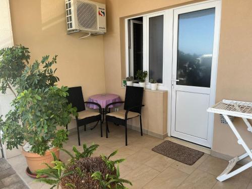 a balcony with chairs and a table and a window at Apartments Nevenka i Josko in Tučepi