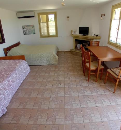 a bedroom with a bed and a table and a desk at Parko Naturale in Kallithéa