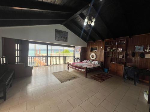 a living room with a bed and a balcony at Seaside House with Private Pier in Chichiriviche