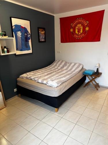 a bed in a room with a flag on the wall at Private Room With Bath Close to the Airport in Njarðvík