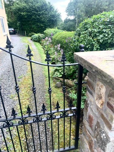 a black iron fence with a garden behind it at Efail Y Garn in Swansea