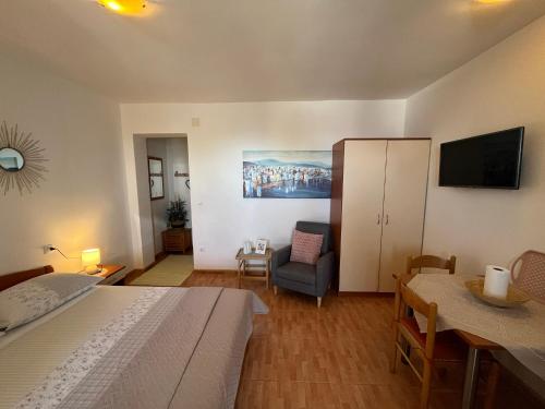 a bedroom with a bed and a couch and a tv at Apartments Nevenka i Josko in Tučepi