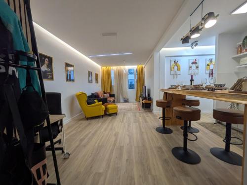 a living room with a table and a yellow chair at PRINCESS FLOWER - Sea, View, Parking, Center in Funchal