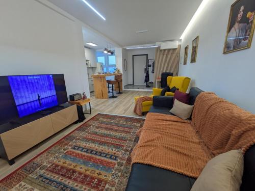 a living room with a couch and a flat screen tv at PRINCESS FLOWER - Sea, View, Parking, Center in Funchal