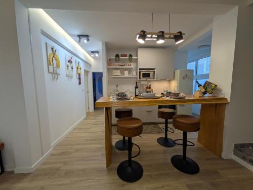 a kitchen with a table and stools in a room at PRINCESS FLOWER - Sea, View, Parking, Center in Funchal
