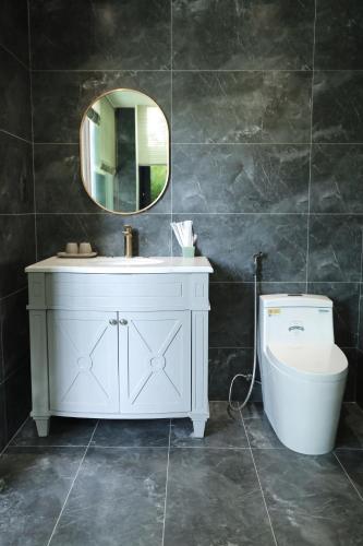 a bathroom with a sink and a toilet and a mirror at Eco Bliss Hotel in Thôn Lại Thê