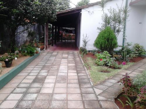 a walkway in a garden with a building at Nueva Alborada Lodging House in Fernando de la Mora
