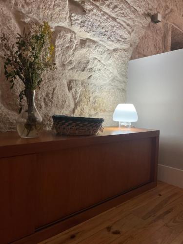 a table with a vase of flowers and a lamp at Centrico Loft Singular y Unico in Vigo