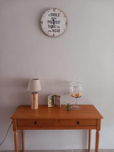 a table with a lamp and a clock on a wall at Chez Paulette in Avelgem