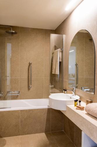 a bathroom with a white tub and a sink at KoSea Boutique Hotel in Kos Town