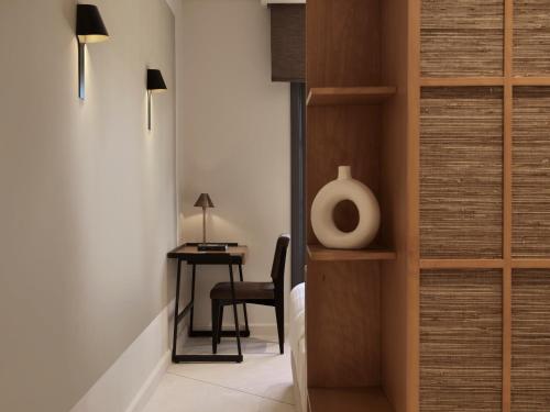 a bedroom with a desk and a chair next to a door at The Chedi El Gouna in Hurghada