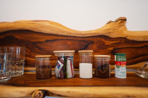a group of glass jars sitting on a wooden table at Unique Suite In Eilat in Eilat