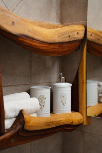three white candles on a wooden shelf with towels at Unique Suite In Eilat in Eilat