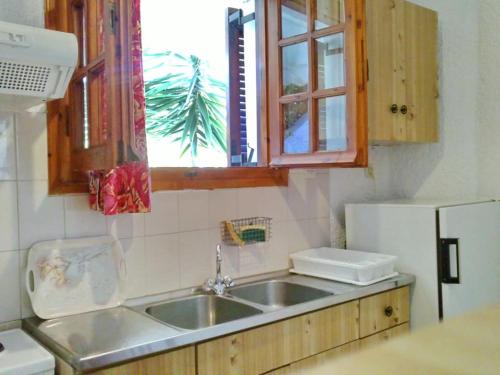a kitchen with a sink and a window at Akrata Golden Beach House in Aíyira