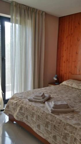a bedroom with a bed with two towels on it at Kairos B&B in San Giuseppe Jato