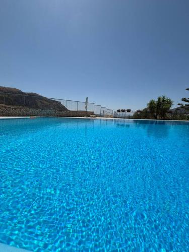 a large pool of blue water with a fence in the background at Kairos B&B in San Giuseppe Jato