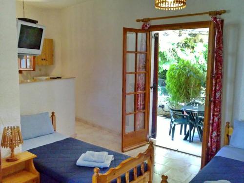 a bedroom with a bed and a door to a patio at Akrata Golden Beach House in Aíyira